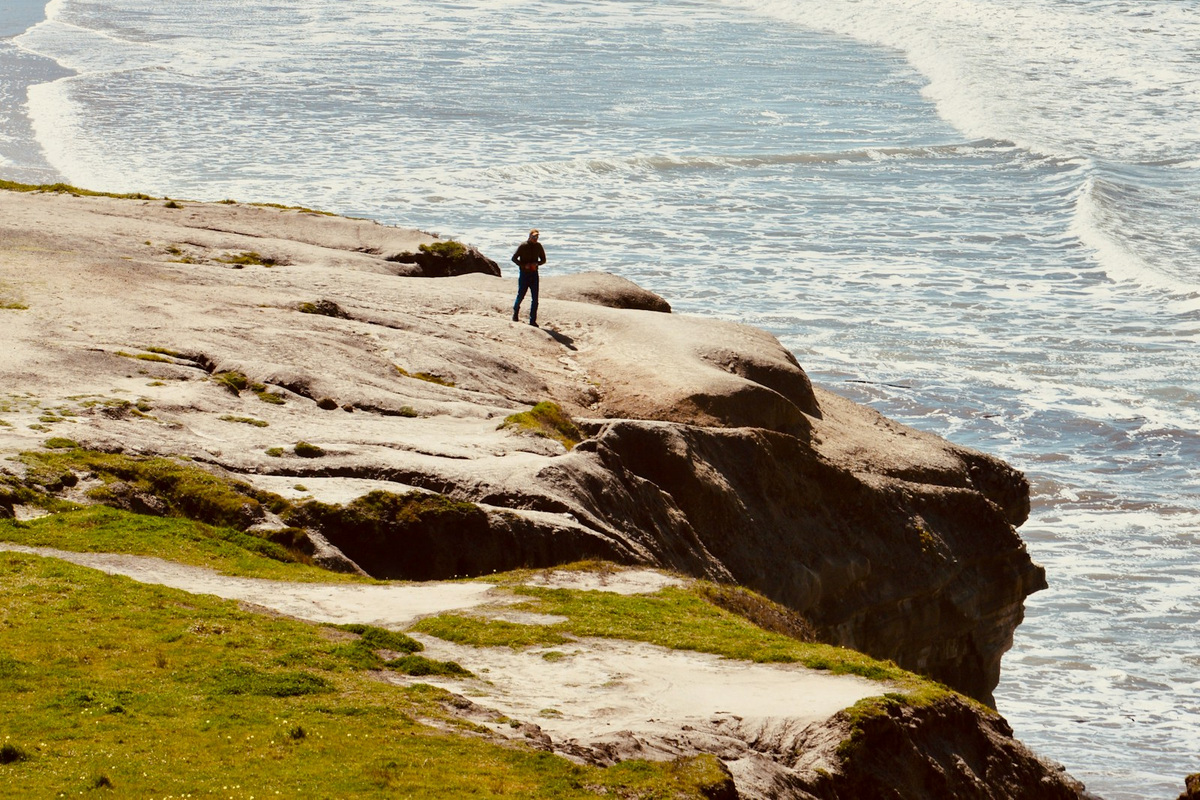 Original photograph: waves and a sunlit rocky coast by Albijona Fejzullahu.